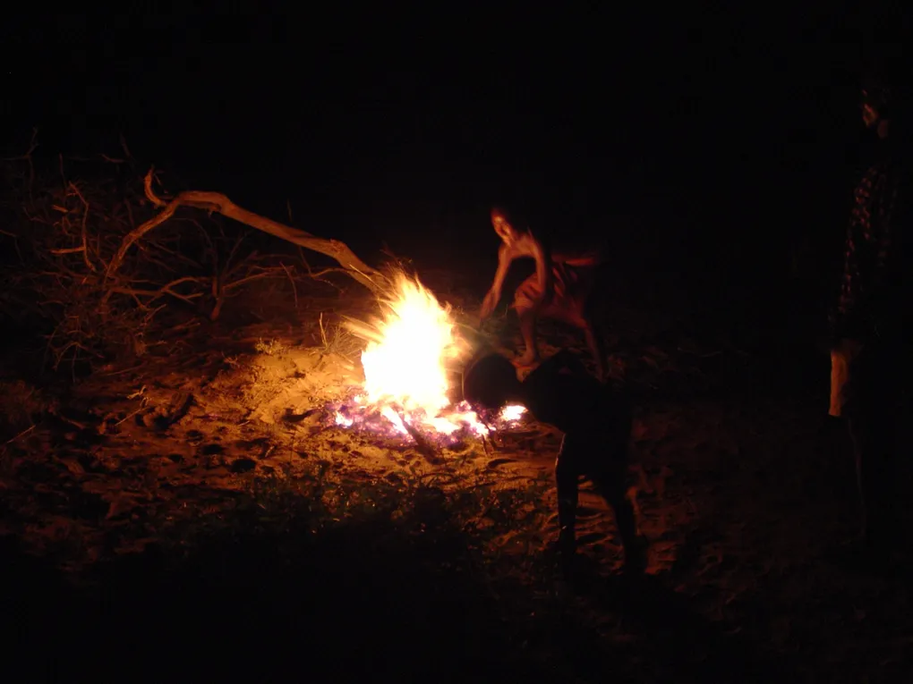 Turkana men roasting a goat as part of a communal meal in northwest Kenya