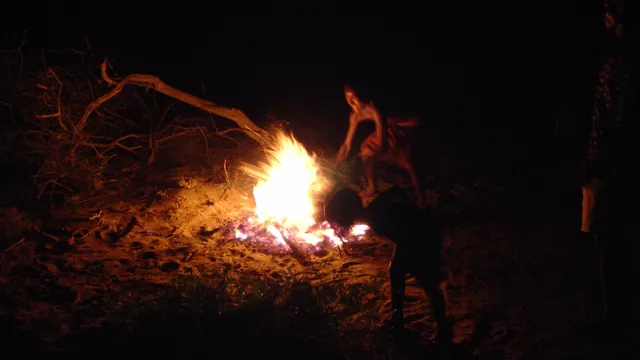 Turkana men roasting a goat as part of a communal meal in northwest Kenya